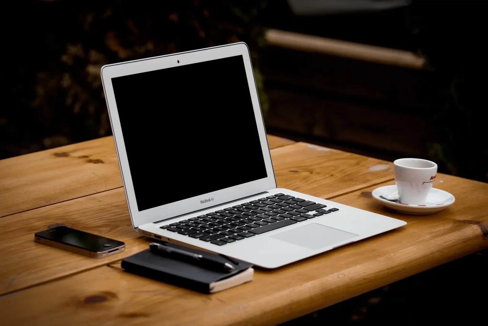 A laptop and notebook on a wooden desk