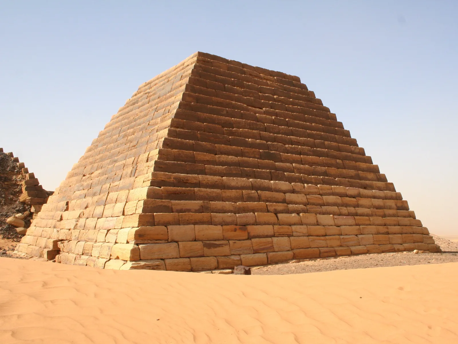 A single restored pyramid at Meroë seen against the desert
