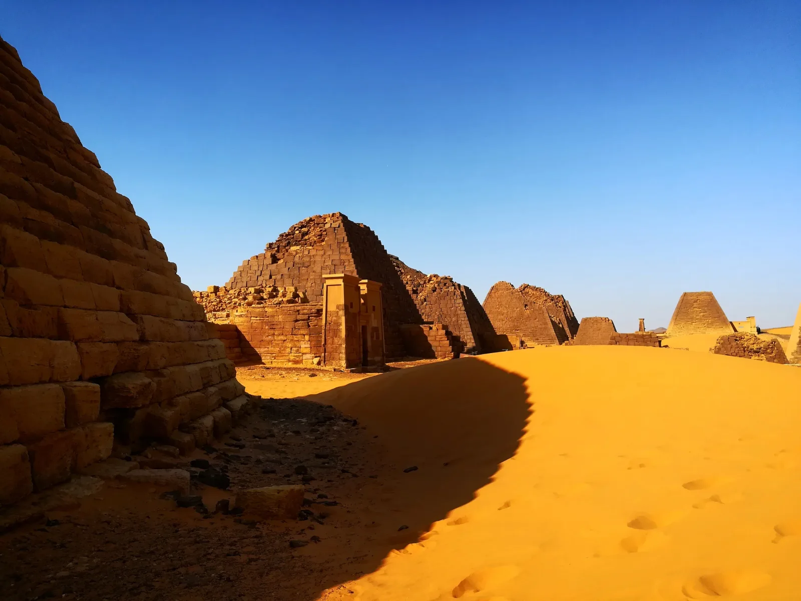 The pyramids of Meroë rising from desert sand under a clear sky