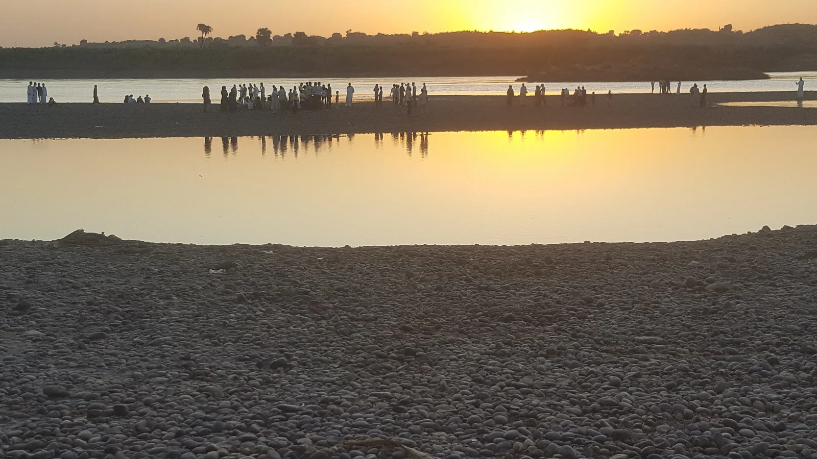 The Blue Nile at sunset, with a distant line of people along the far bank