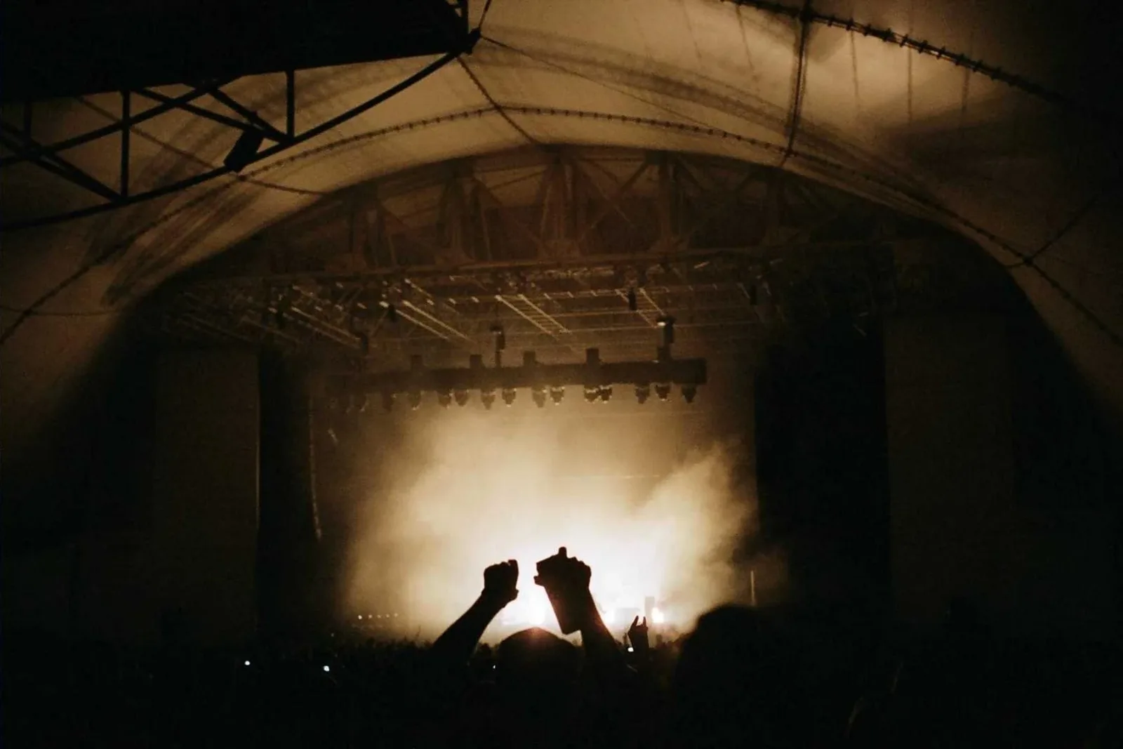 A crowd gathered in low light, faces indistinct