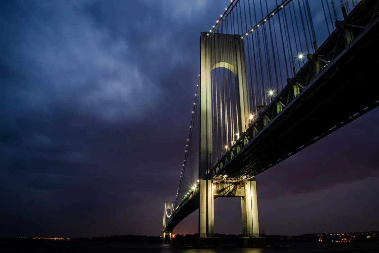 A suspension bridge lit against the night sky